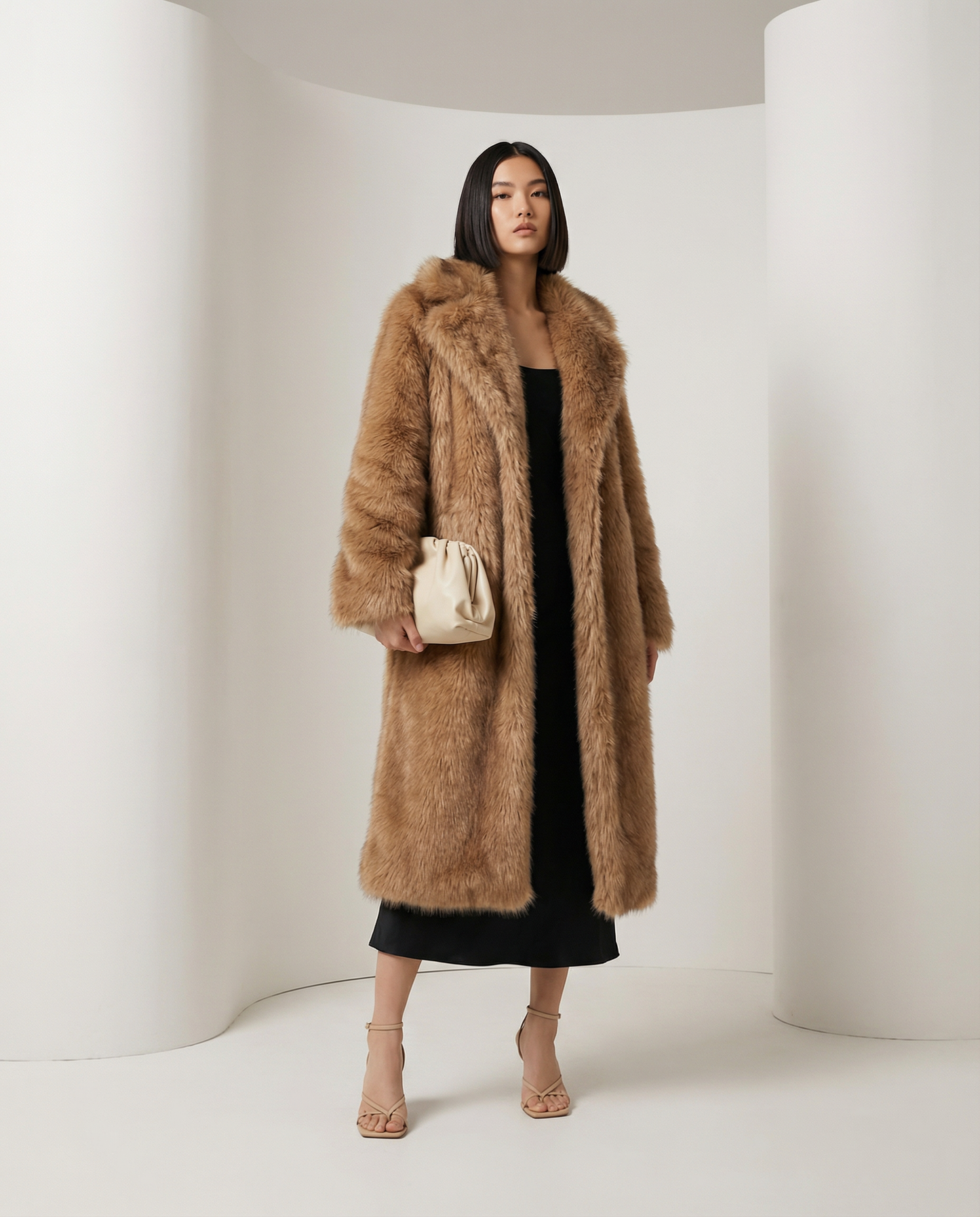 Amber fox faux-fur coat with a deep shawl collar, three-quarter view over a black slip dress