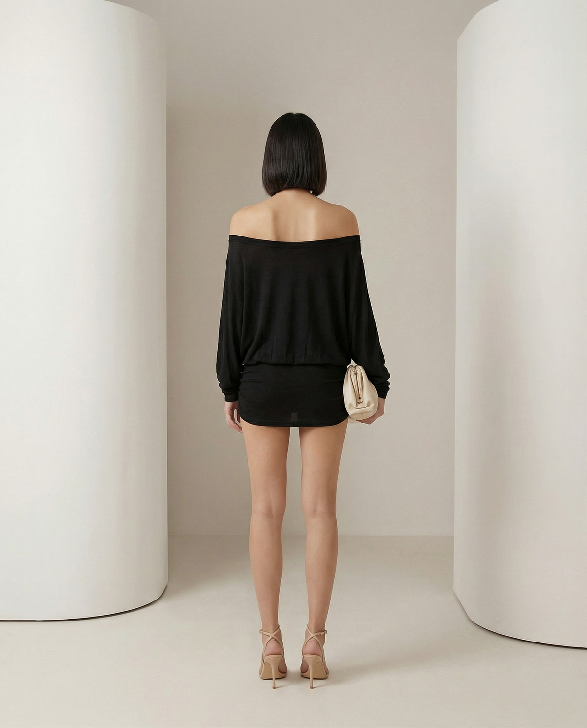 Back view of the black off-shoulder mini dress, bare shoulders and gathered mini skirt