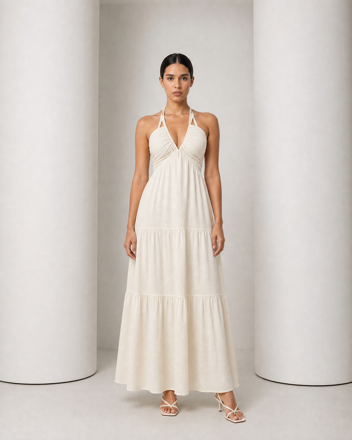 Model in the cream Alva dress, halter V neckline and tiered maxi skirt