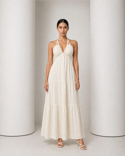 Model in the cream Alva dress, halter V neckline and tiered maxi skirt