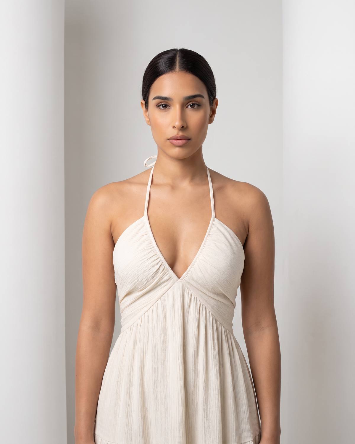 Close view of the Alva bodice in cream, deep V halter with gathered panels and crinkle texture