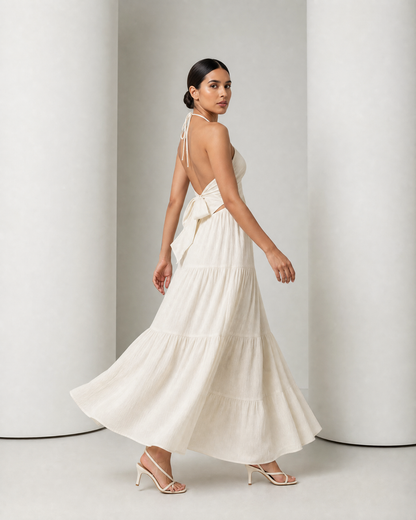 Side view of the cream Alva dress in movement, the tiered skirt swinging out