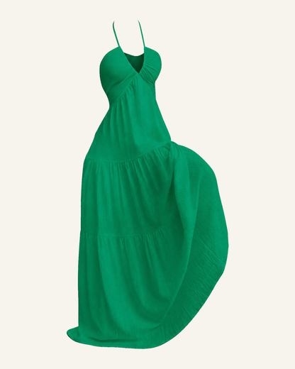 The Alva halter tiered maxi dress in emerald green, shown alone against a bone background, full length