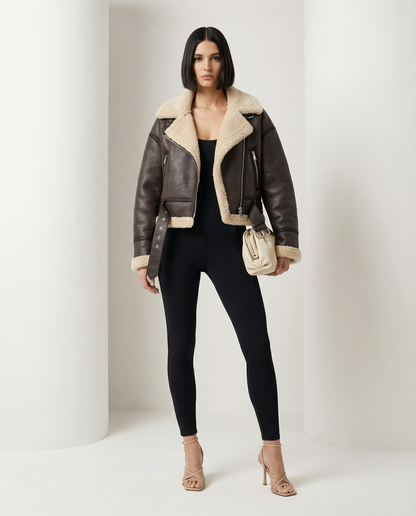 Brown aviator jacket with cream shearling trim and a buckled waist strap, three-quarter view