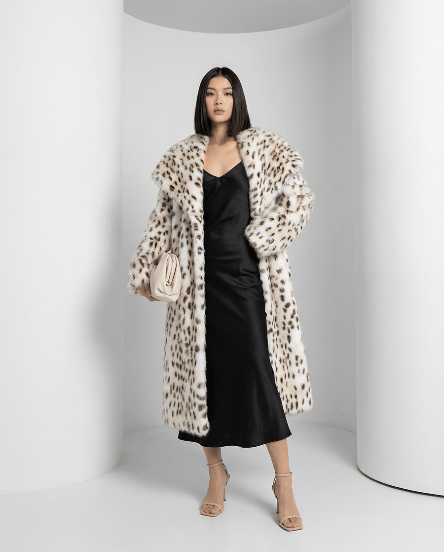 Asteria snow-leopard faux-fur coat worn open over a black midi dress, front view, full length