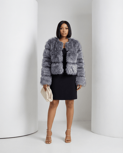 Glacier grey Astra faux-fur jacket worn open over a black mini dress, full length