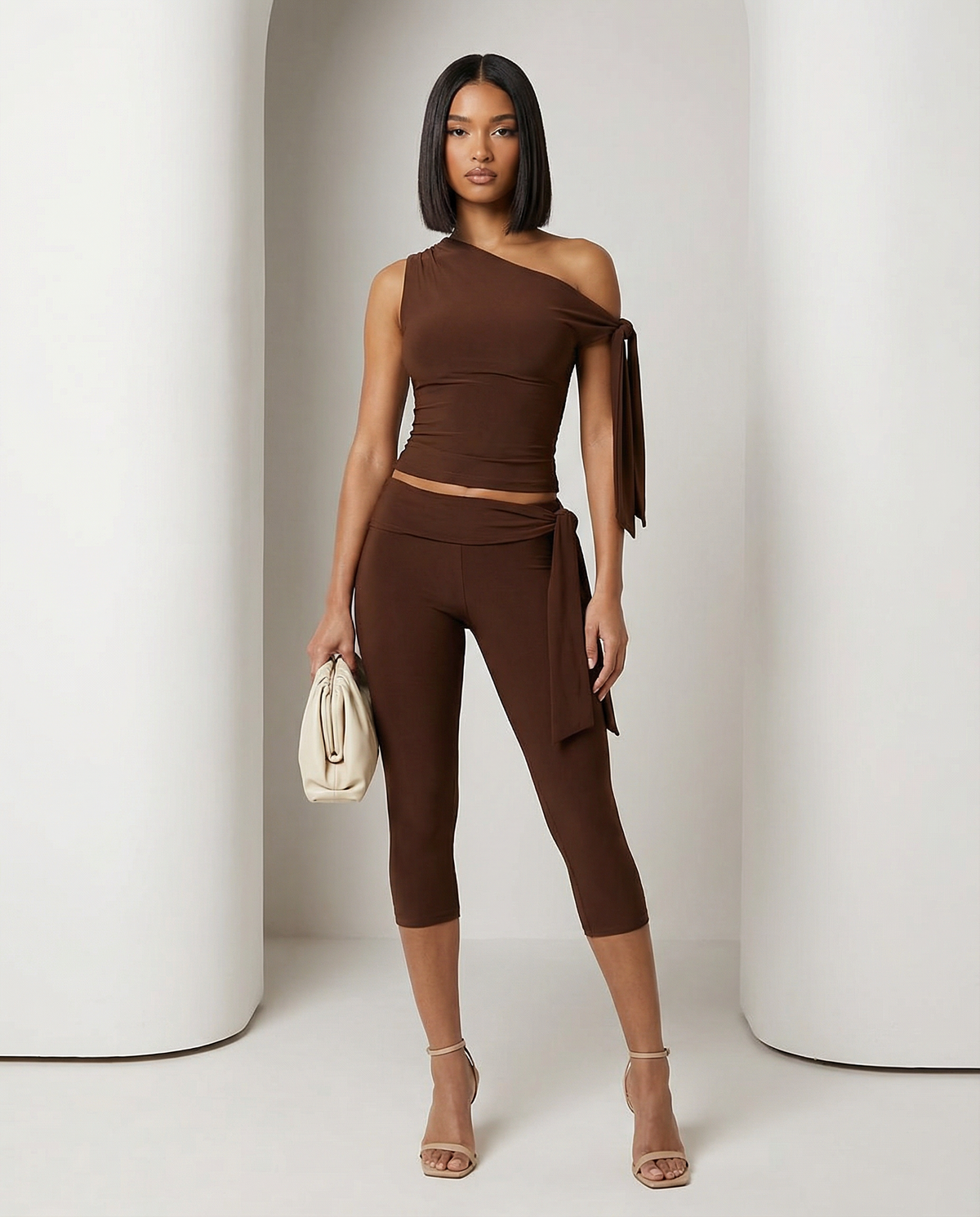 Bitter chocolate Aura asymmetric set with one-shoulder tie top and capri leggings, full length