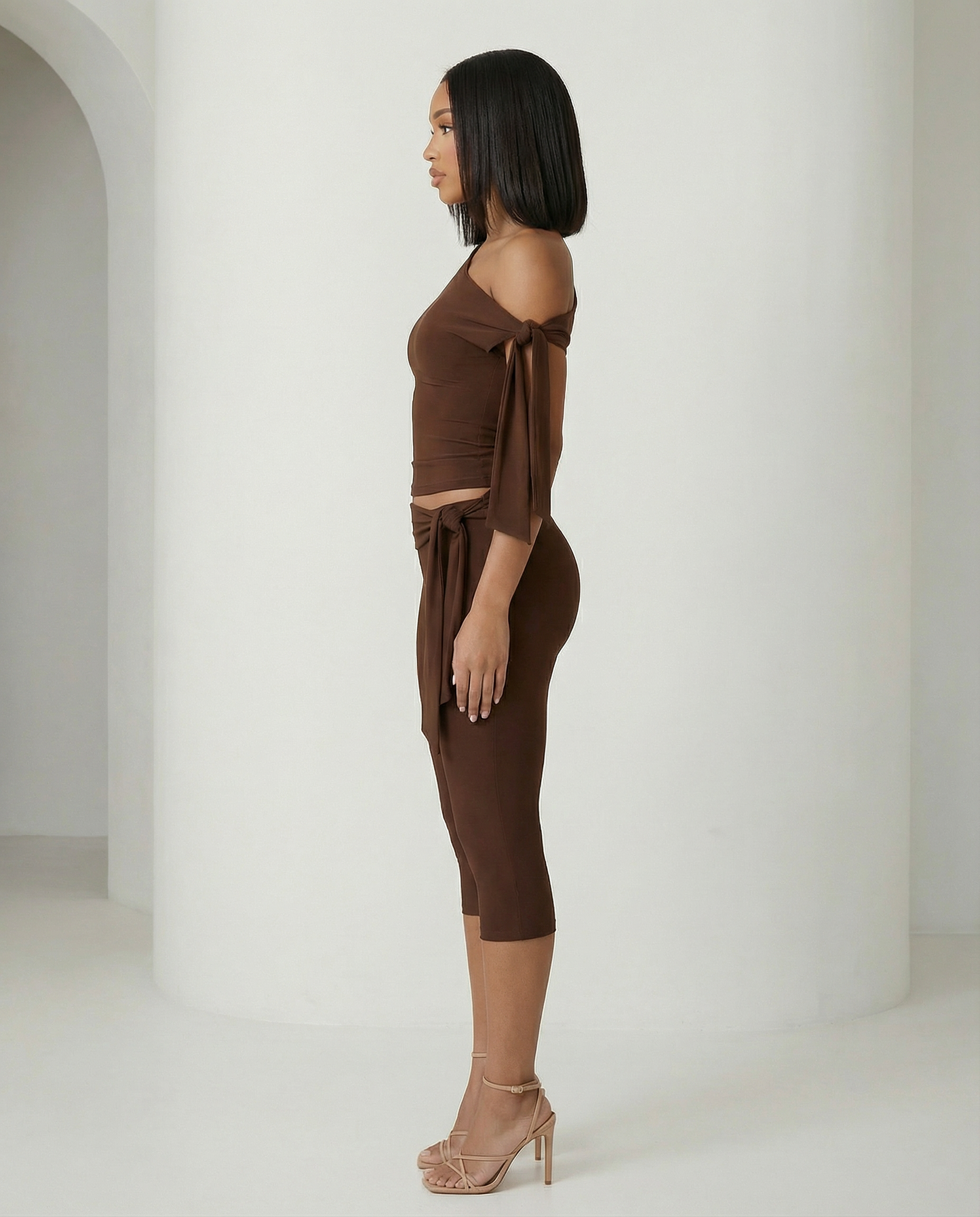 Aura asymmetric set in bitter chocolate seen in profile, shoulder tie and waist sash hanging loose