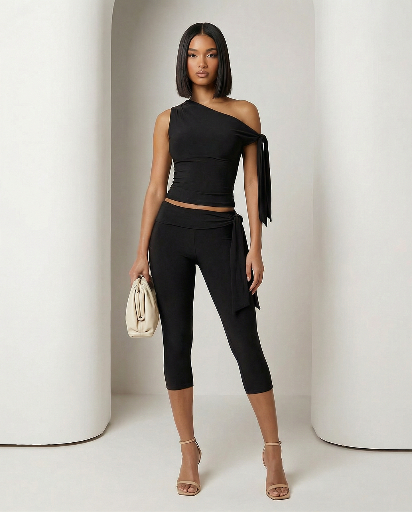Black Aura asymmetric set with a one-shoulder tie top and cropped capri leggings, full length