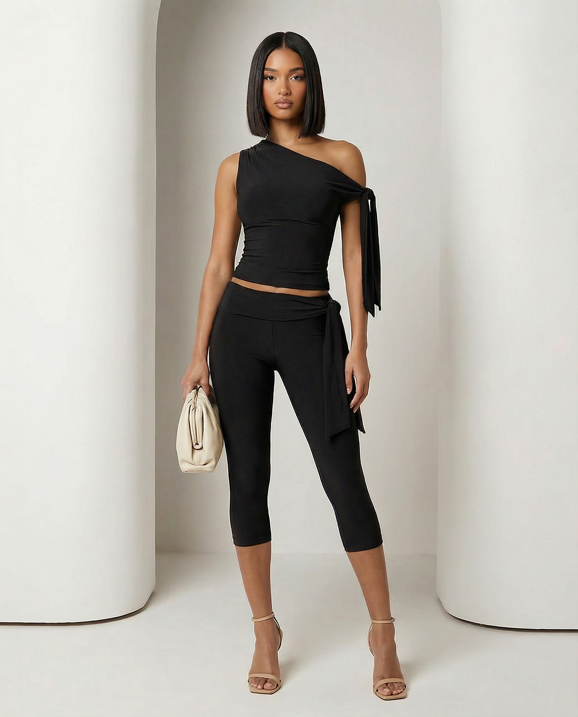 Black Aura asymmetric set with a one-shoulder tie top and cropped capri leggings, full length