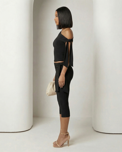 Aura asymmetric set in black seen in profile, shoulder tie knotted at the bare upper arm