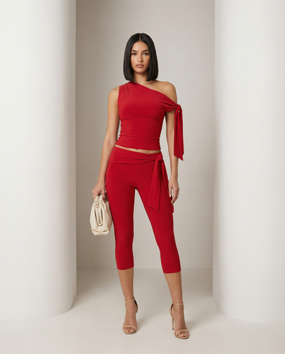 Scarlet red one-shoulder top with knotted tie worn over matching capri leggings, front view