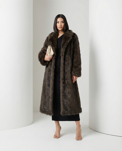 Brown Eden longline faux-fur coat worn open with a cream clutch held at the waist, full length
