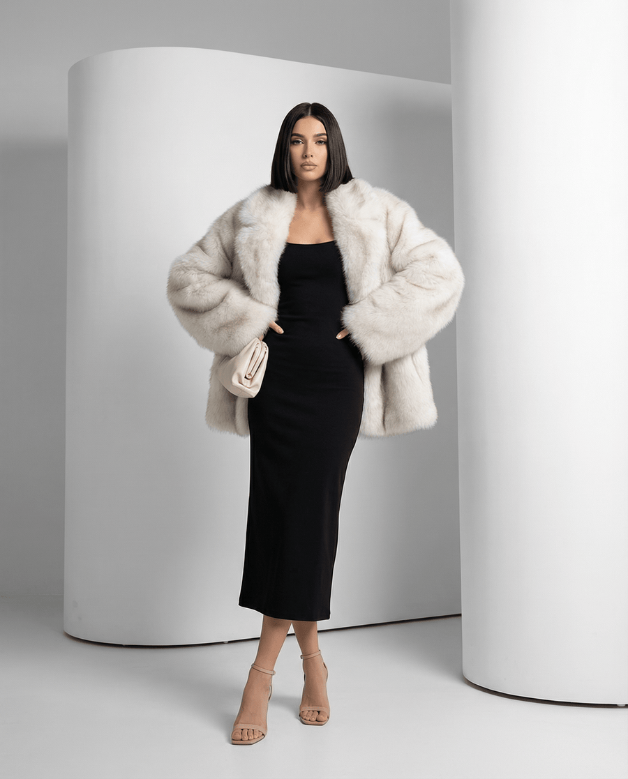 Frosted white Elara oversized faux-fur coat worn open over a black midi dress, full length