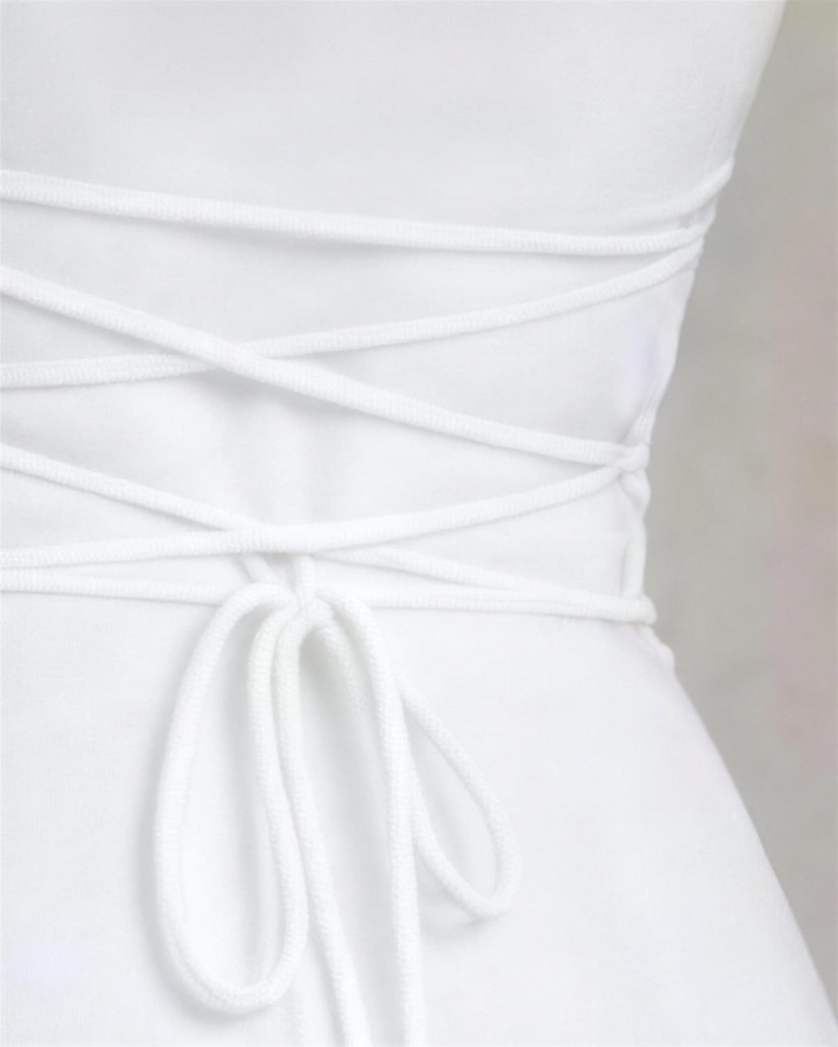 Detail of the Elin corset back, soft cord crossing the gathered waistband and tied in a bow