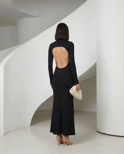 Back view of the black long-sleeve maxi with a round open back cut-out and fluted hem