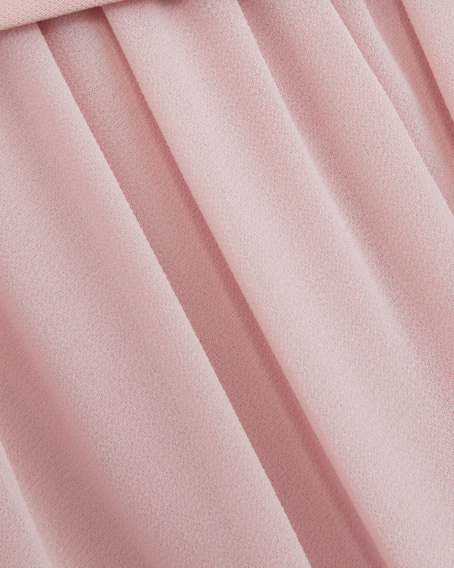Macro of the Embla blush chiffon, showing the fine crepe texture and the fall of the gathered skirt