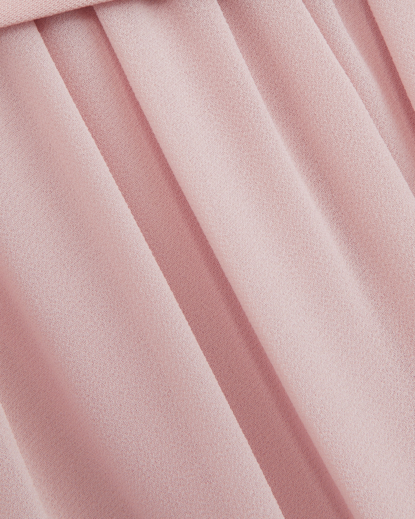 Macro of the Embla blush chiffon, showing the fine crepe texture and the fall of the gathered skirt