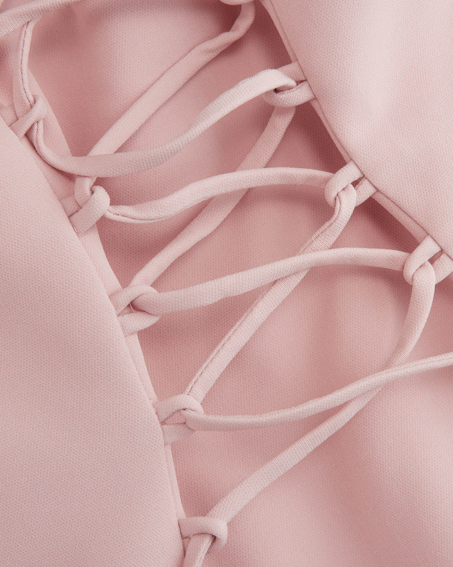 Close view of the Embla corset lacing, blush cord threaded through knotted fabric loops, no hardware