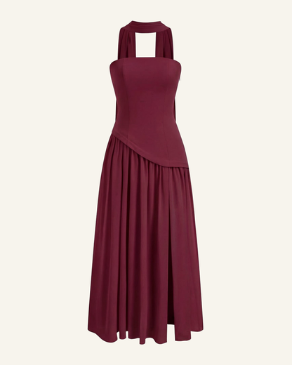 The Embla lace-back maxi in burgundy, strapless bodice and full chiffon skirt, alone on a bone background