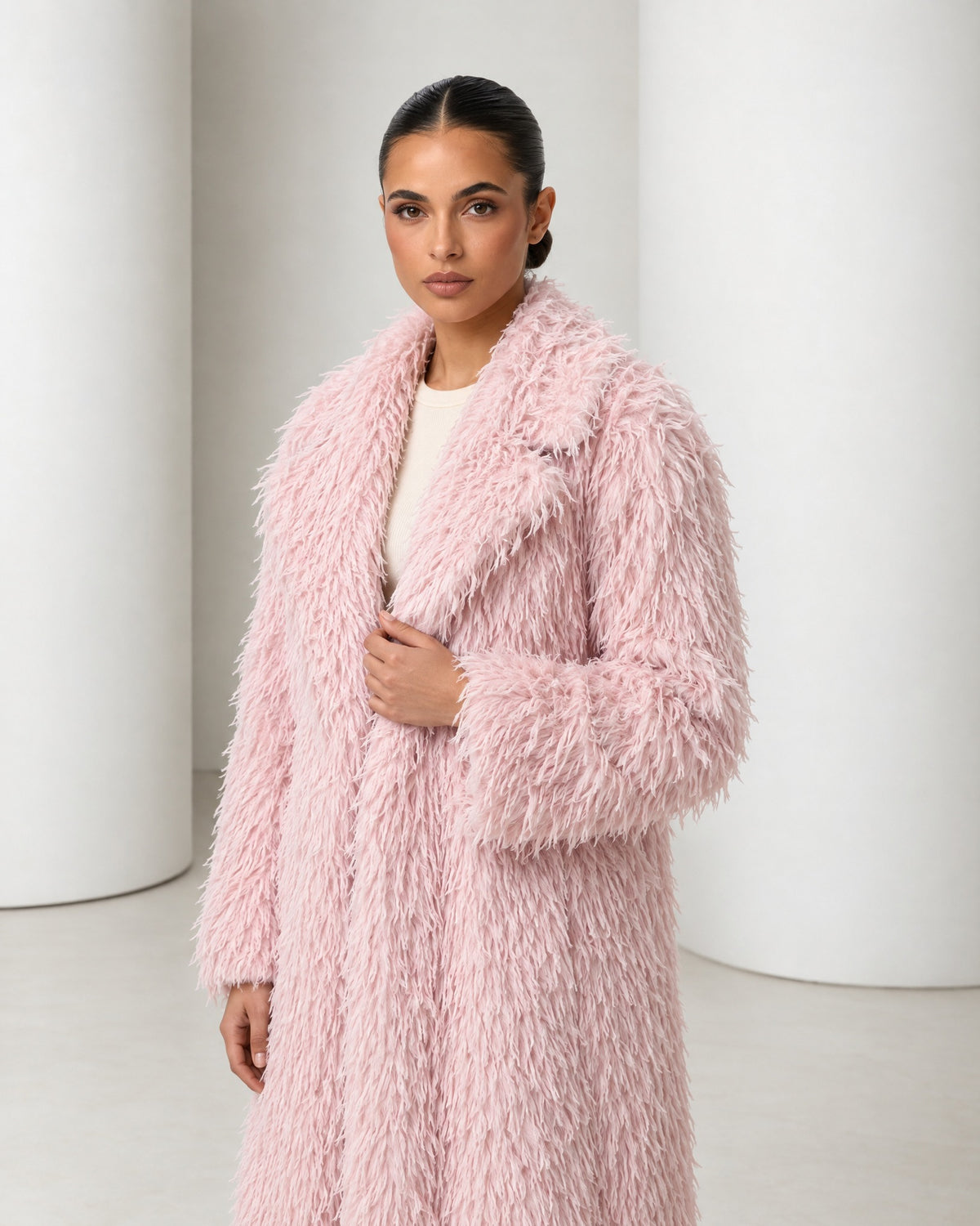 Close view of the Freja coat in blush, wide feathered lapels framing the face