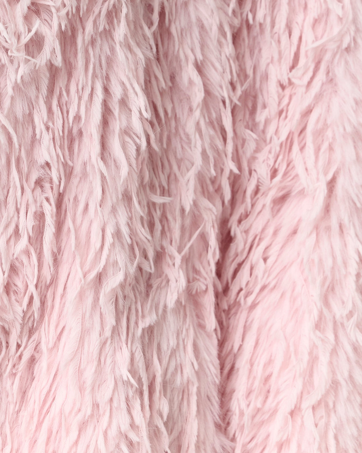 Detail of the long feathered faux fur pile on the Freja coat in blush