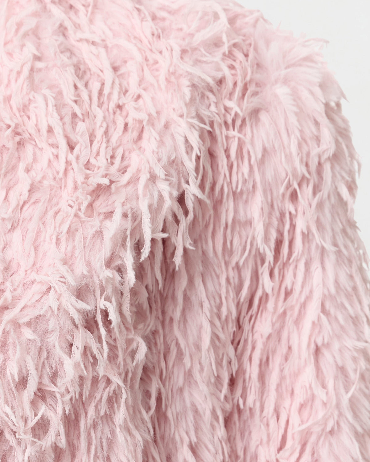 Detail of the wide notched lapel and shoulder on the Freja blush coat
