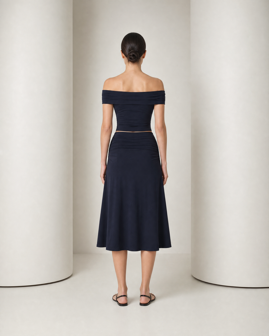 Model in the navy Hedda set, off-shoulder band top and high-waisted A-line midi skirt