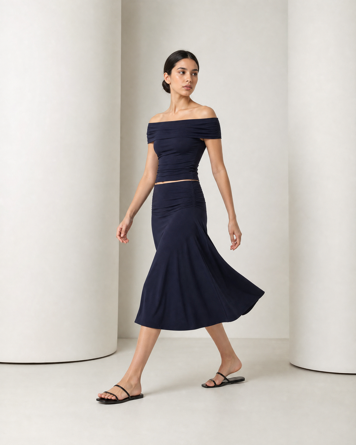 Side view of the navy Hedda set in movement, the A-line skirt swinging out at mid-calf