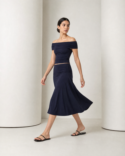 Side view of the navy Hedda set in movement, the A-line skirt swinging out at mid-calf