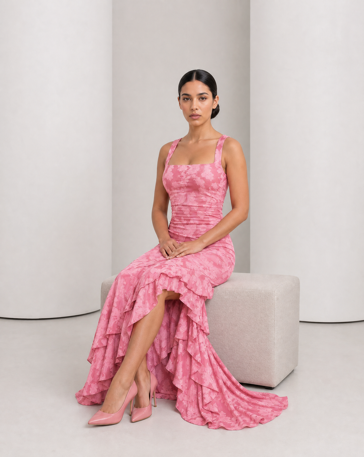 Model seated in the Ilva rose maxi, tiered ruffle hem spread across the floor beside her