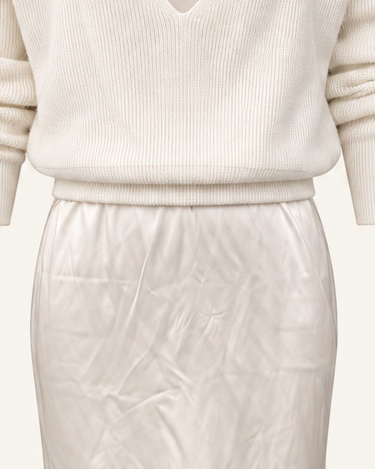Detail of the ribbed hem band on the Ingrid sweater where it meets the ivory satin