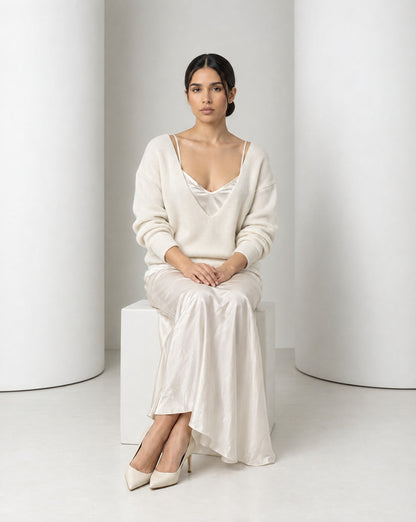 Ingrid set in cream worn seated, satin draping over the knees to ivory pumps