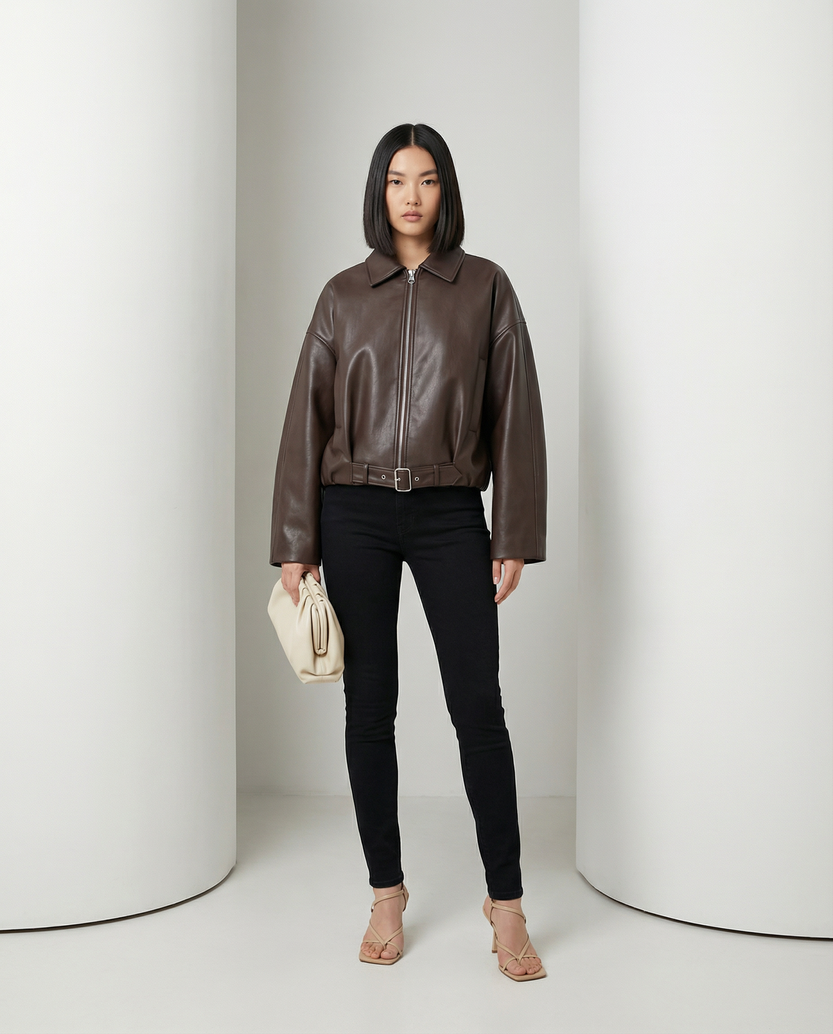 Bitter chocolate Ivy cropped jacket zipped over black skinny jeans, belted at the waist