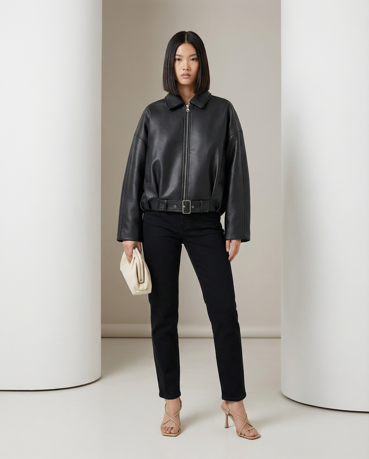 Black Ivy cropped jacket with open collar and buckled belt, front view over straight-leg jeans