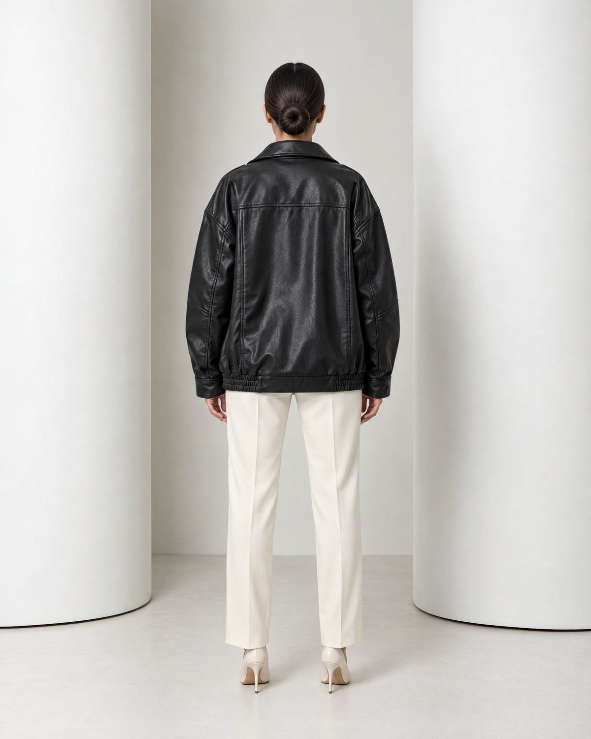 Back view of the Liv jacket in black, dropped shoulders and gathered hem at the hip