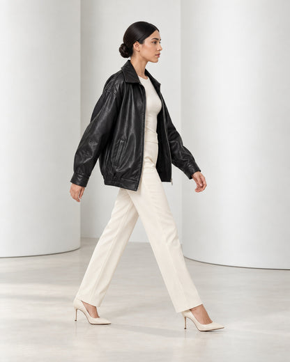 Side view of the Liv jacket in black mid-stride, showing its roomy oversized shape