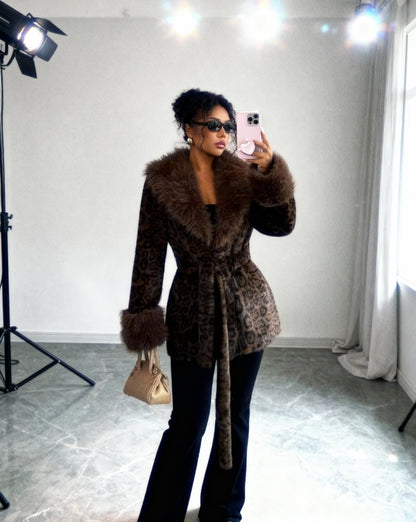Cocoa leopard faux-fur coat belted, mirror selfie beside studio lights, three-quarter view