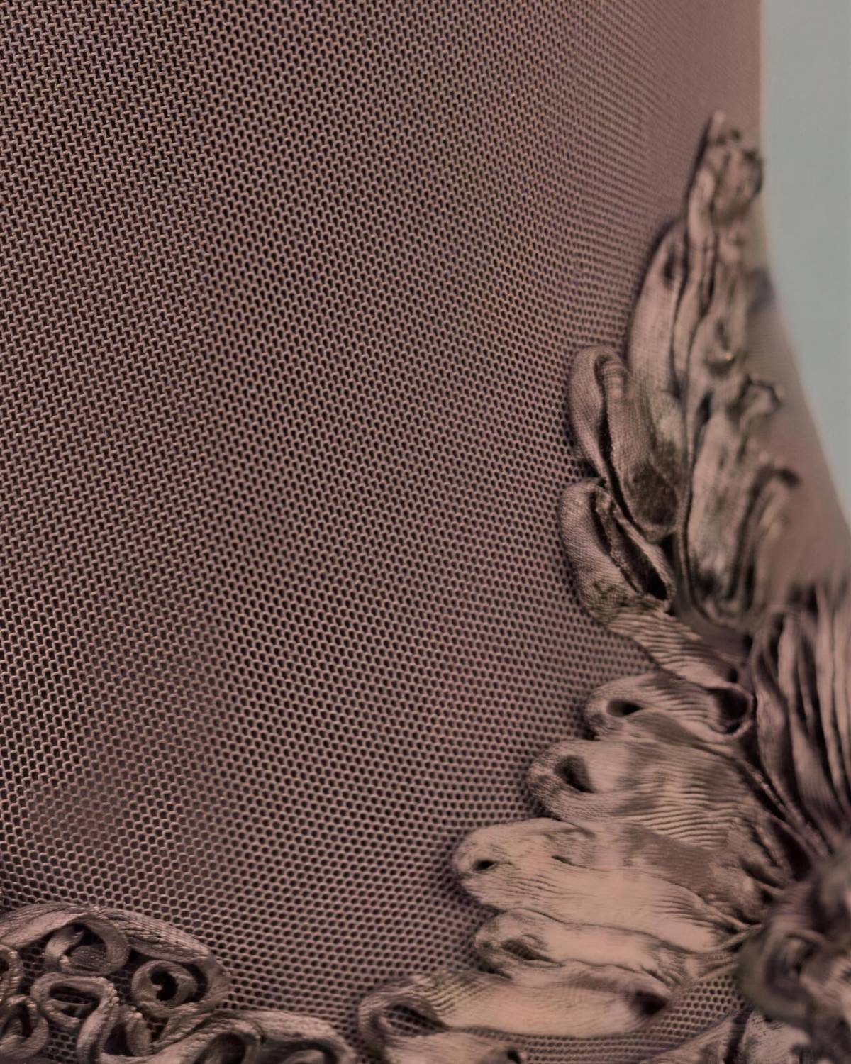 Close view of the Maren mesh ground on the sample, showing the fine transparent weave and the edge of the raised ribbon appliqué