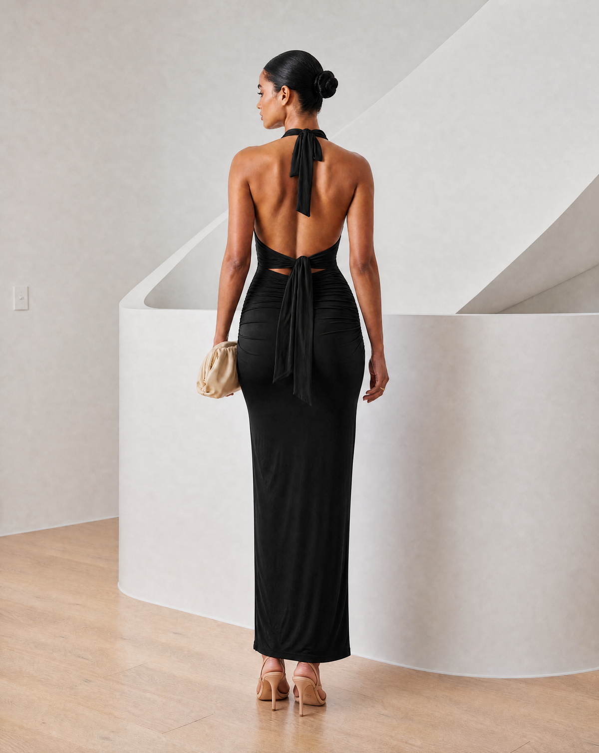 Black halter maxi from behind showing the open back, tie sash and low ruched waist