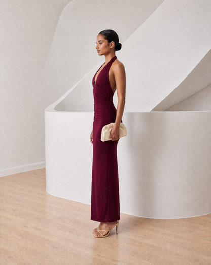 Meridiane halter maxi in burgundy, side profile showing the plunge neckline and column silhouette