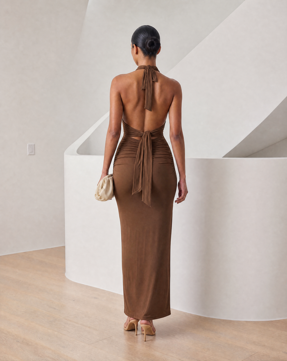 Cocoa brown halter maxi seen from the back with a knotted tie sash and open back panel