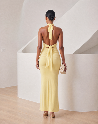 Light yellow halter maxi from the back with bare shoulders and a long tie sash down the spine