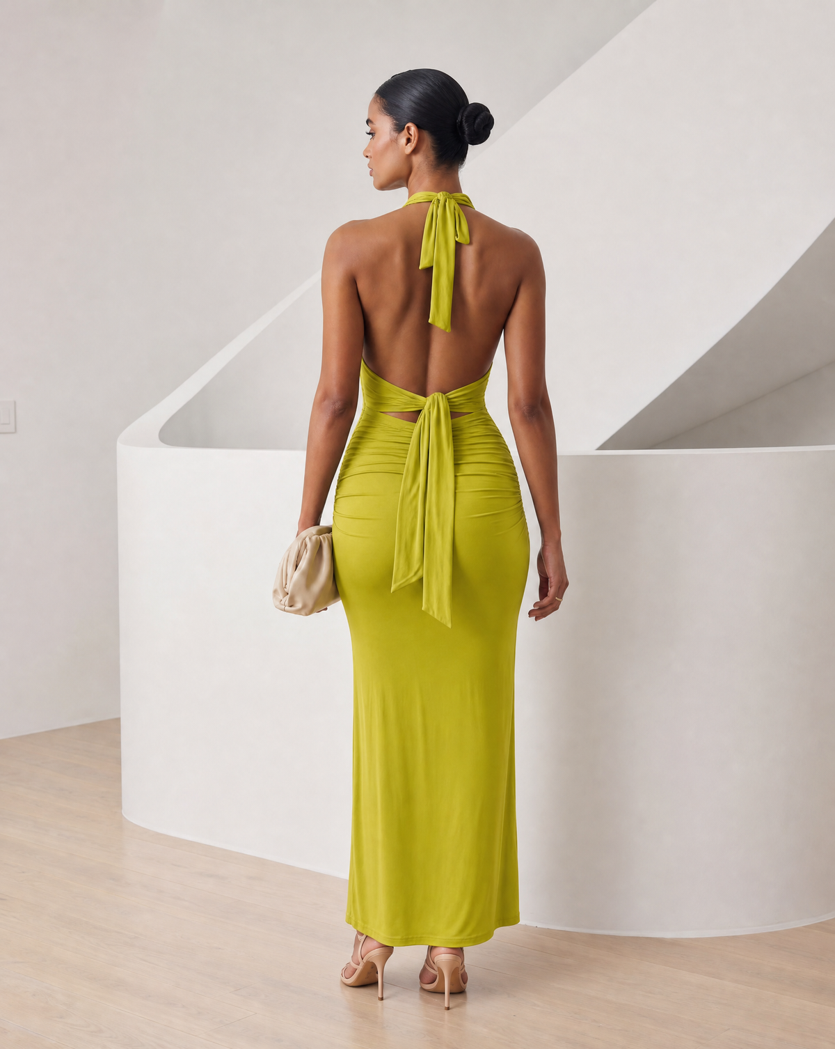 Matcha green halter maxi from behind, open back with the neck tie falling over ruched hips
