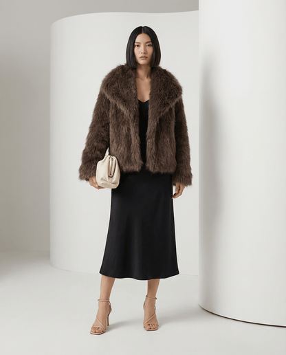 Chocolate brown Neriah plush faux-fur jacket worn open over a black slip midi dress, full length