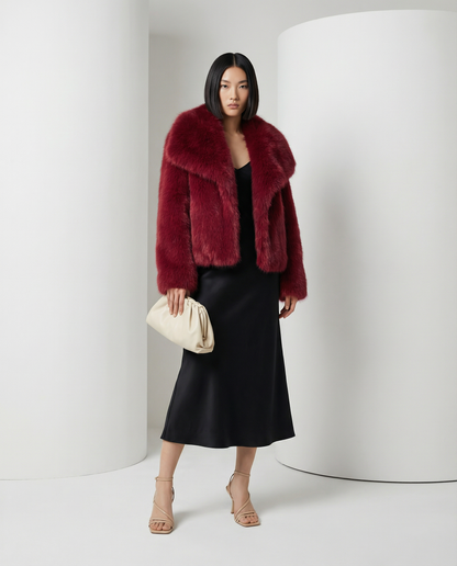 Deep burgundy red cropped faux-fur jacket with a wide shawl collar over a black bias midi dress