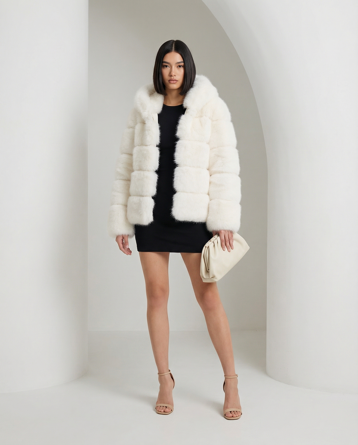 Cream Nova faux-fur bubble jacket worn open over a black mini dress, full length beneath a white arch
