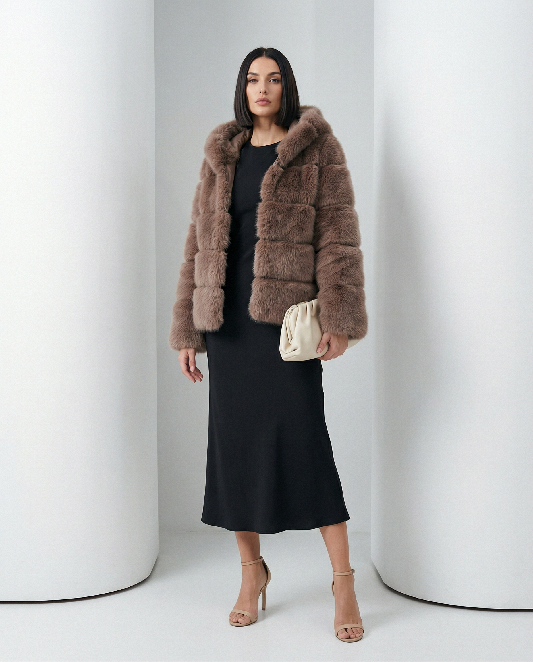 Taupe brown faux-fur bubble jacket over a black bias-cut midi dress, full length standing