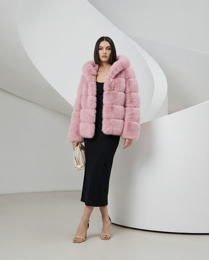 Rose pink faux-fur bubble jacket worn open over a black midi dress, full length three-quarter pose