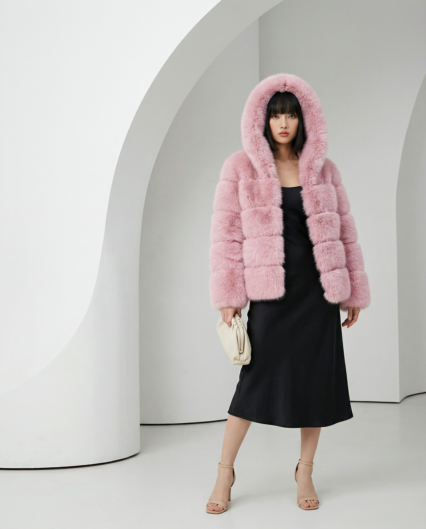 Nova faux-fur bubble jacket in rose pink with the hood up, worn over a black satin slip dress